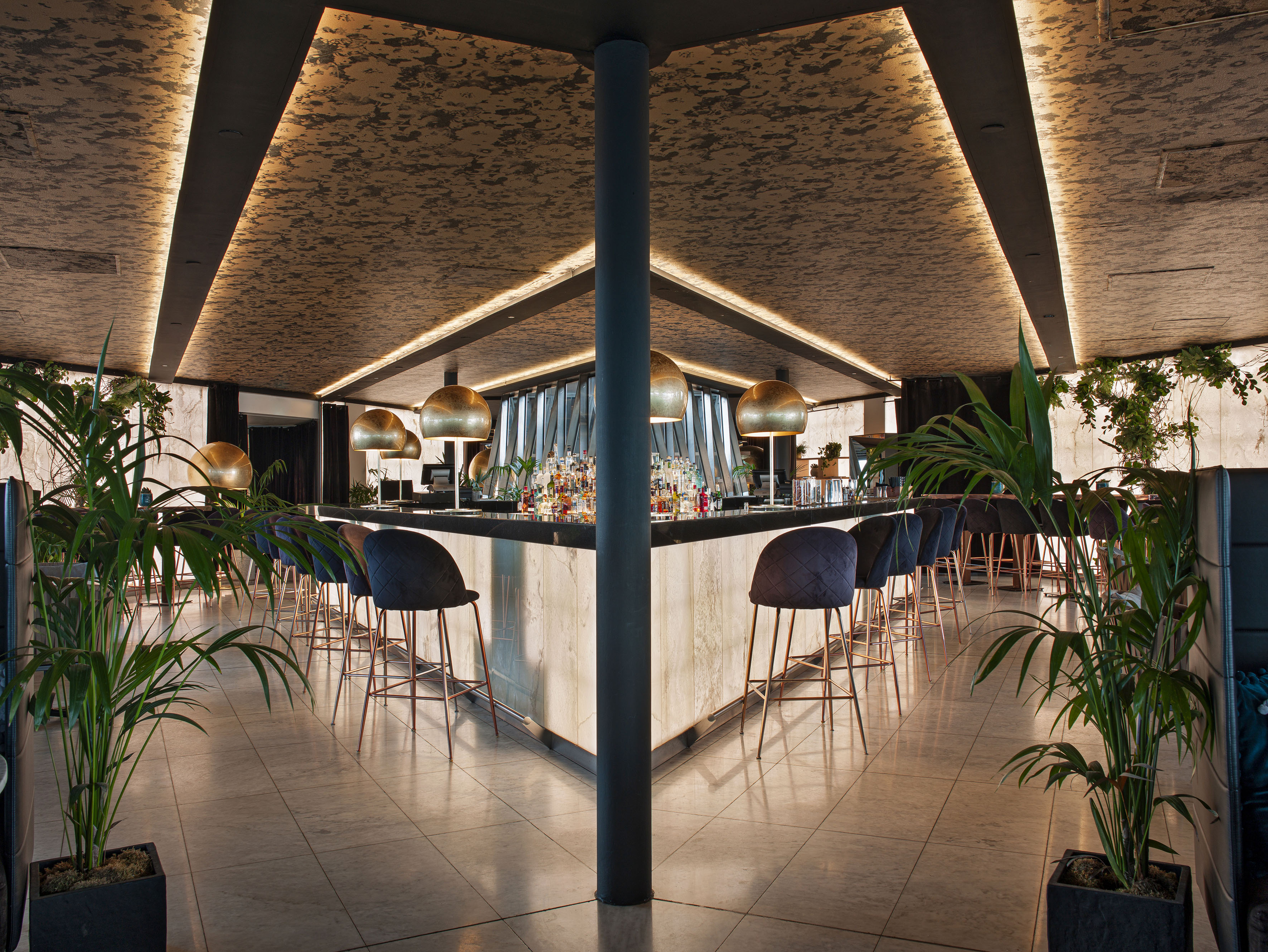 a bar with chairs and plants