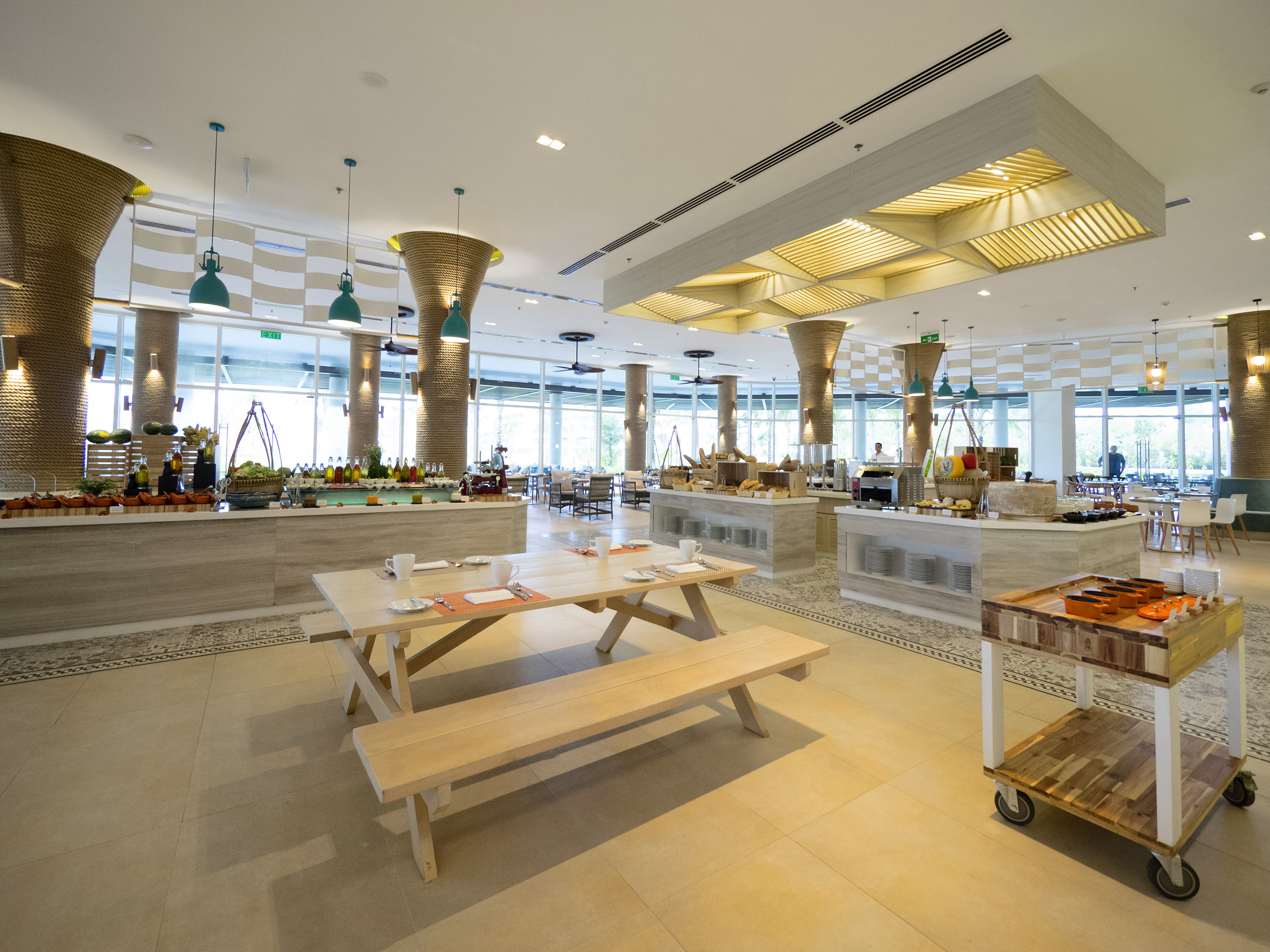 Contemporary buffet dining hall with varied food offerings and picnic-style tables.