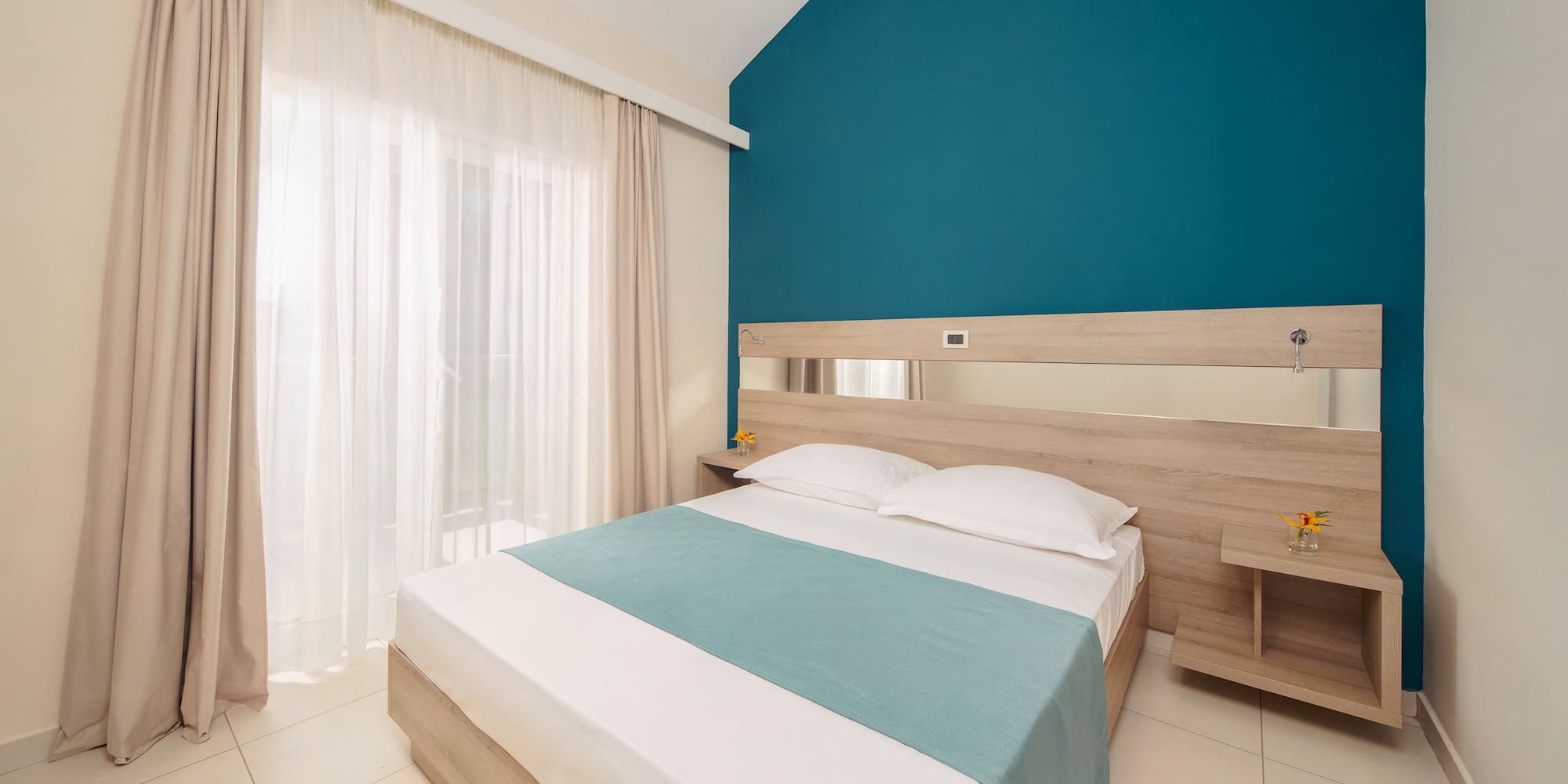 a bedroom with a blue wall and white curtains