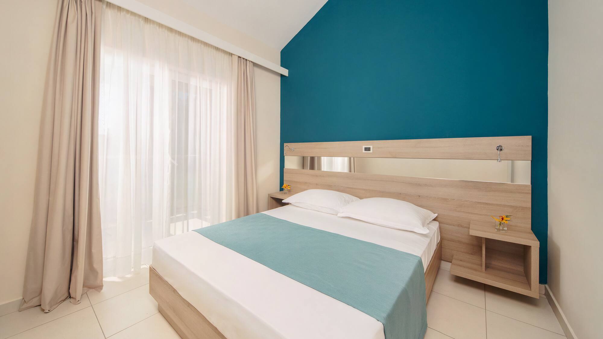 a bedroom with a blue wall and white curtains