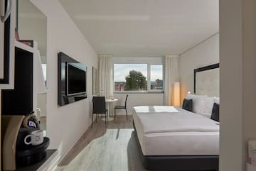 a room with a bed and a television