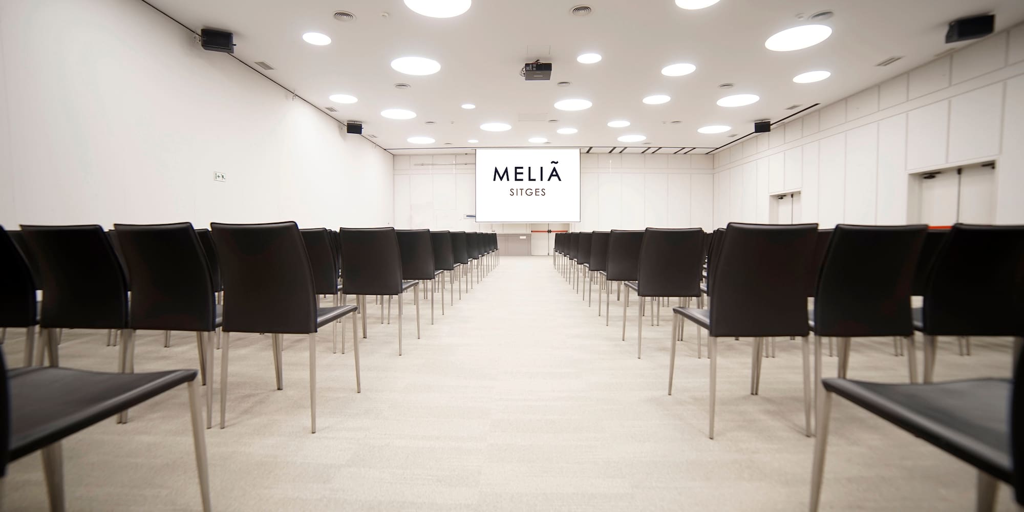 a room with black chairs and a screen