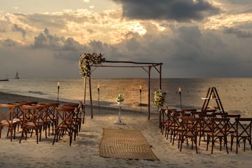 a beach setting with chairs and flowers