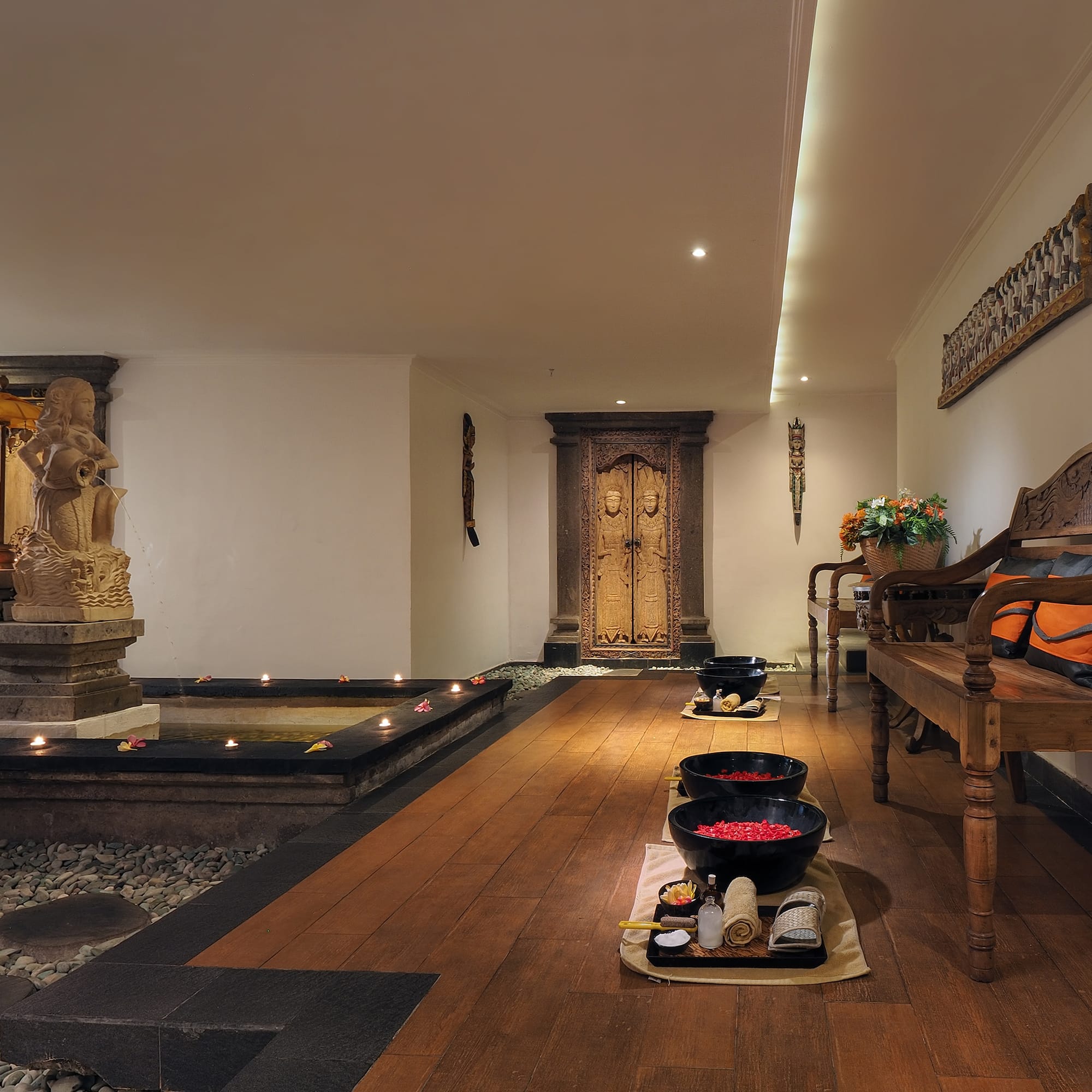 a room with a wood floor and a bench and a fountain