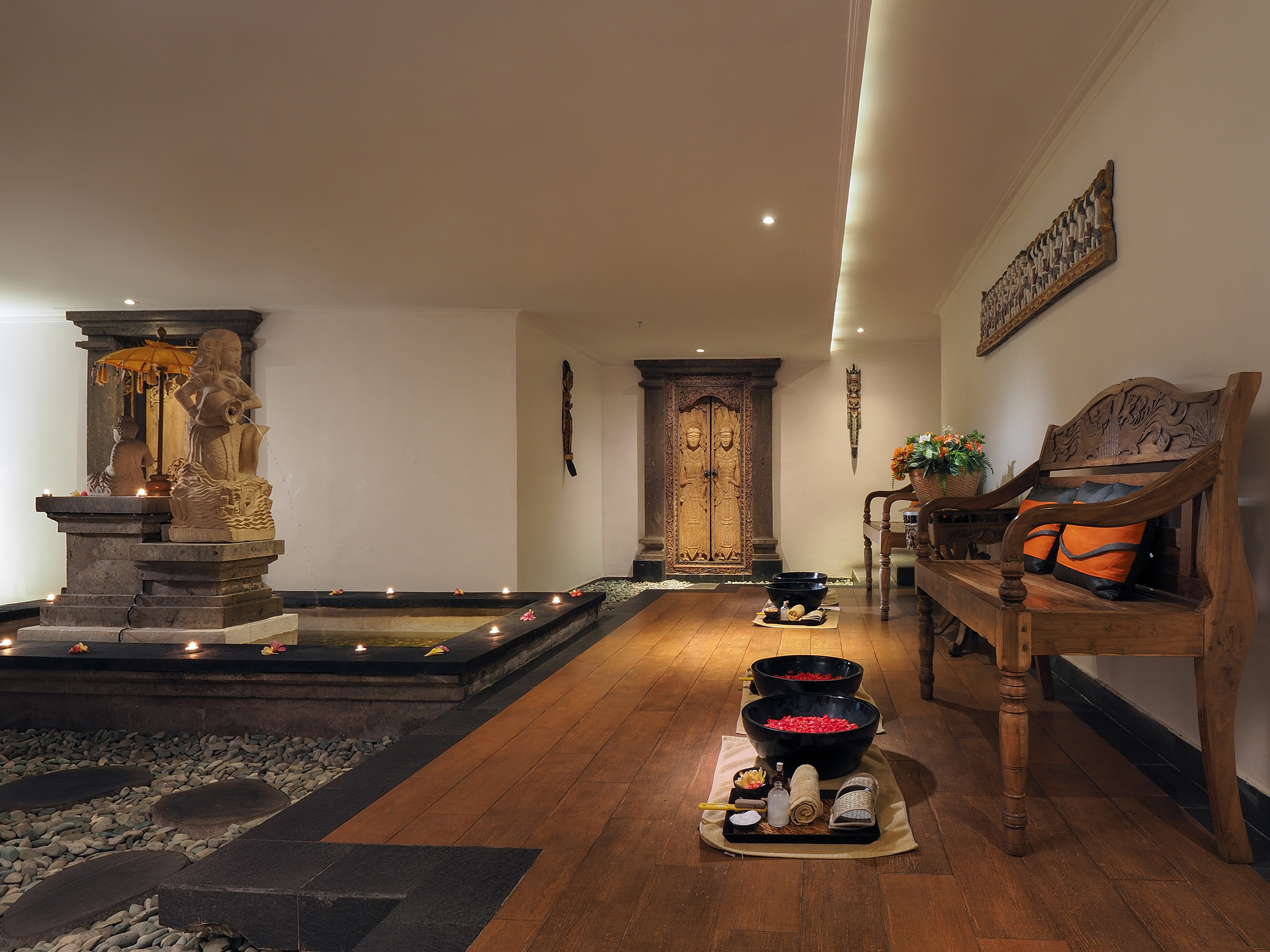 a room with a wood floor and a bench and a fountain