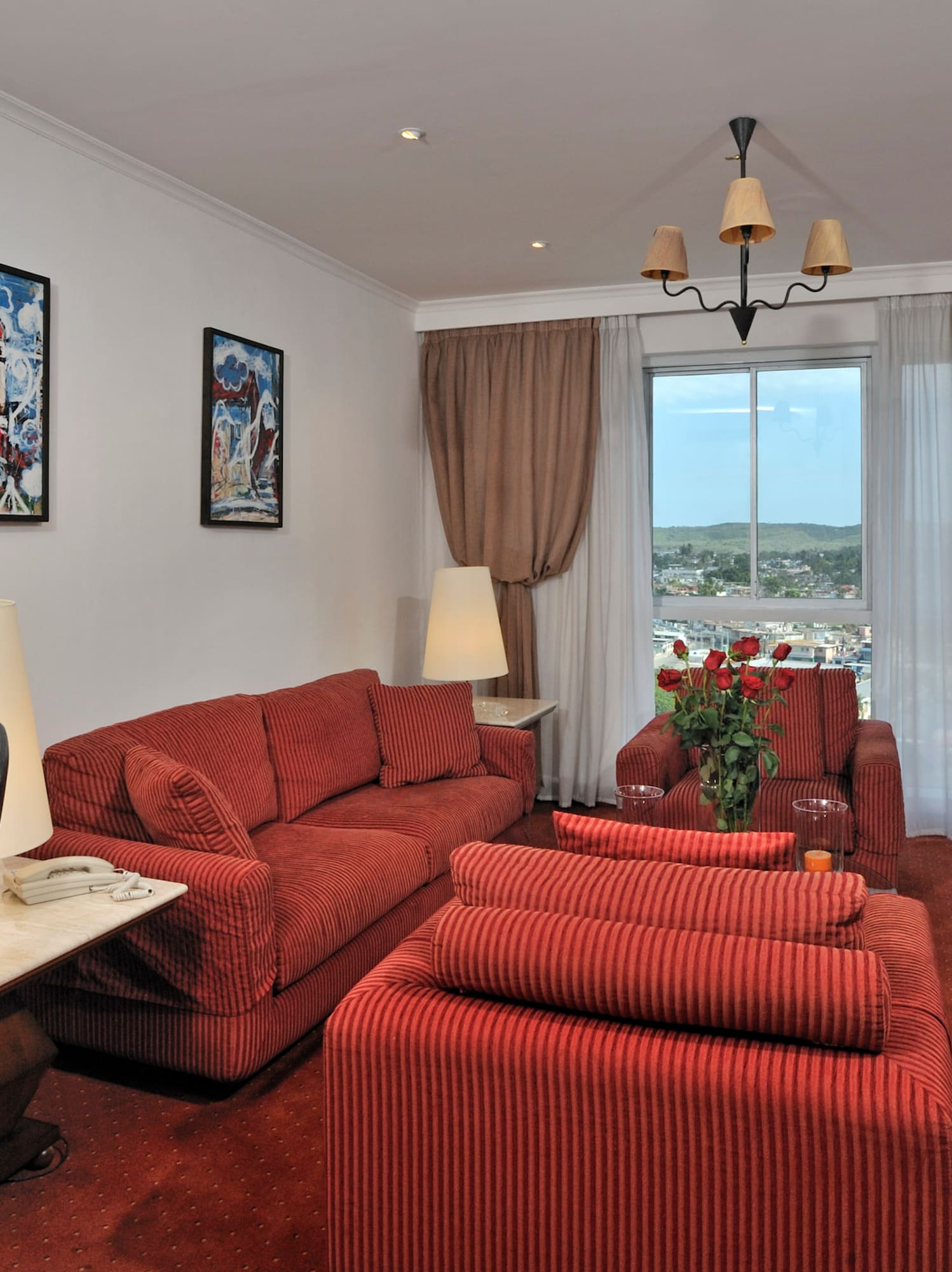 a living room with red couches and a desk