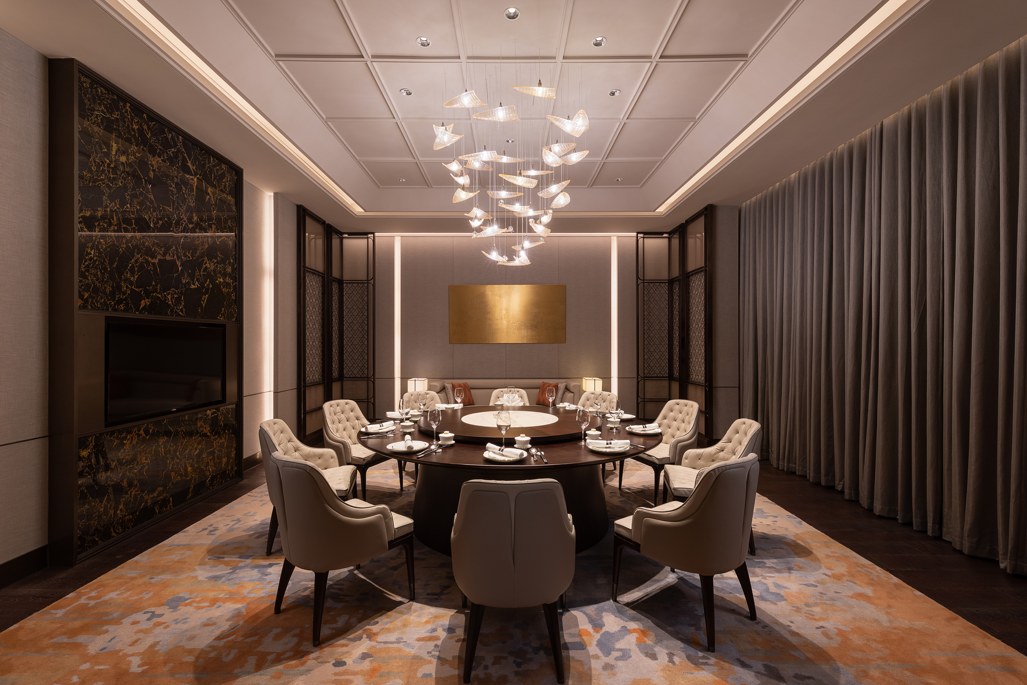 Luxury private dining room with modern chandelier and round table.