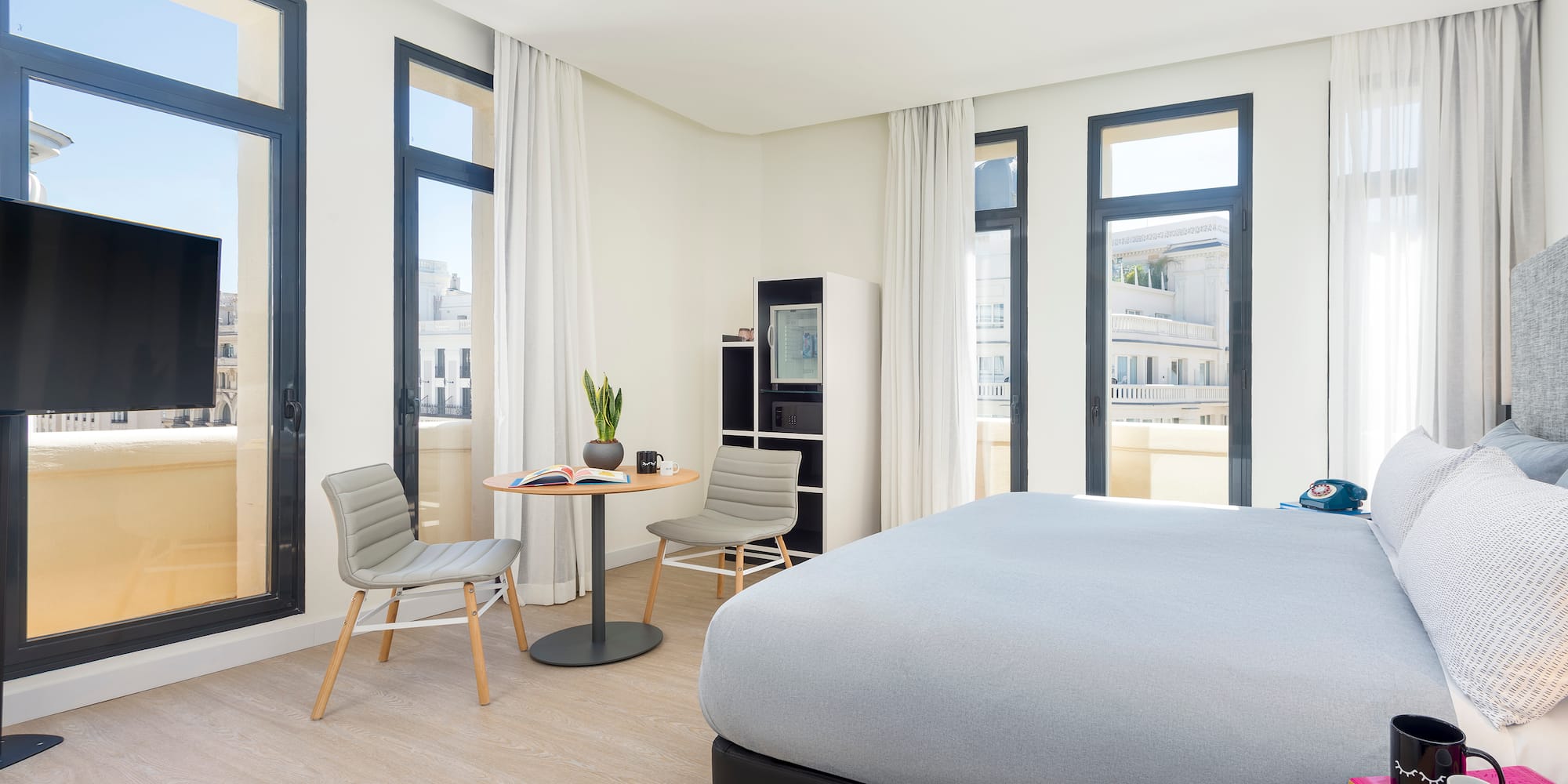 a room with a bed and chairs