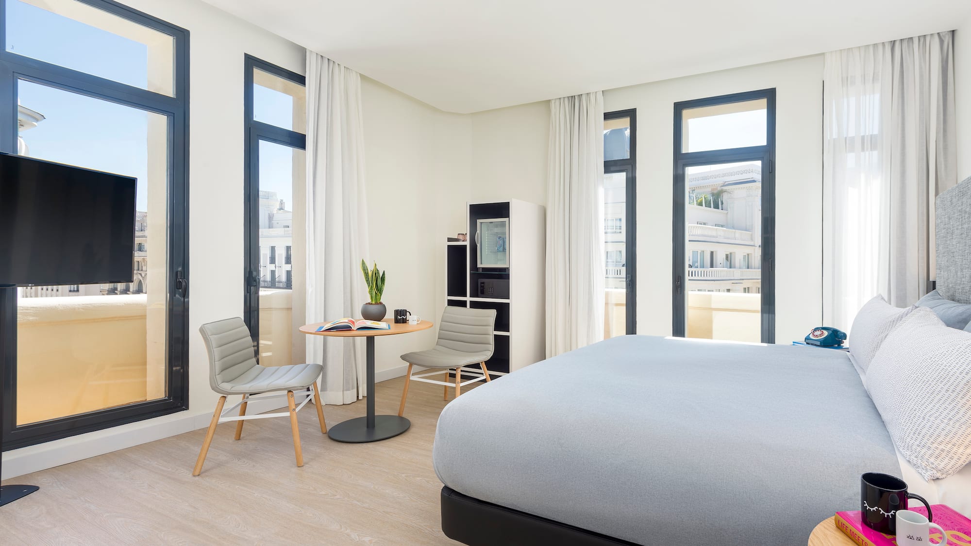 a room with a bed and chairs