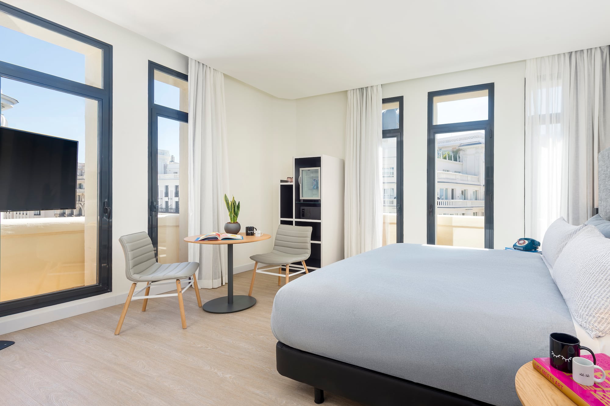 a room with a bed and chairs