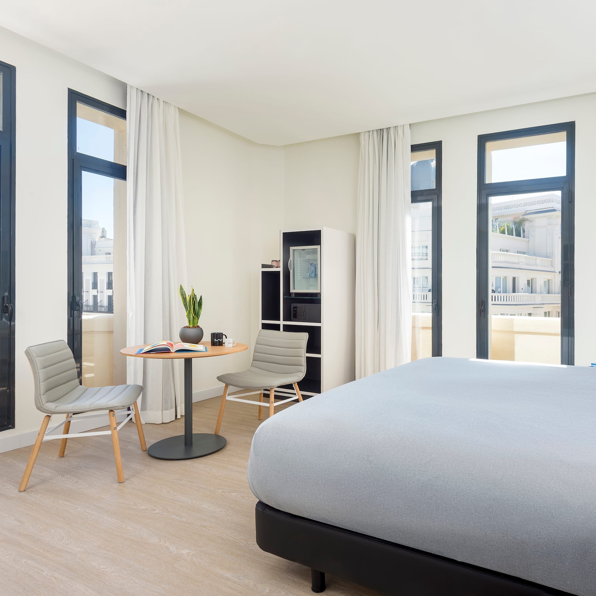 a room with a bed and chairs