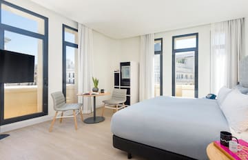 a room with a bed and chairs