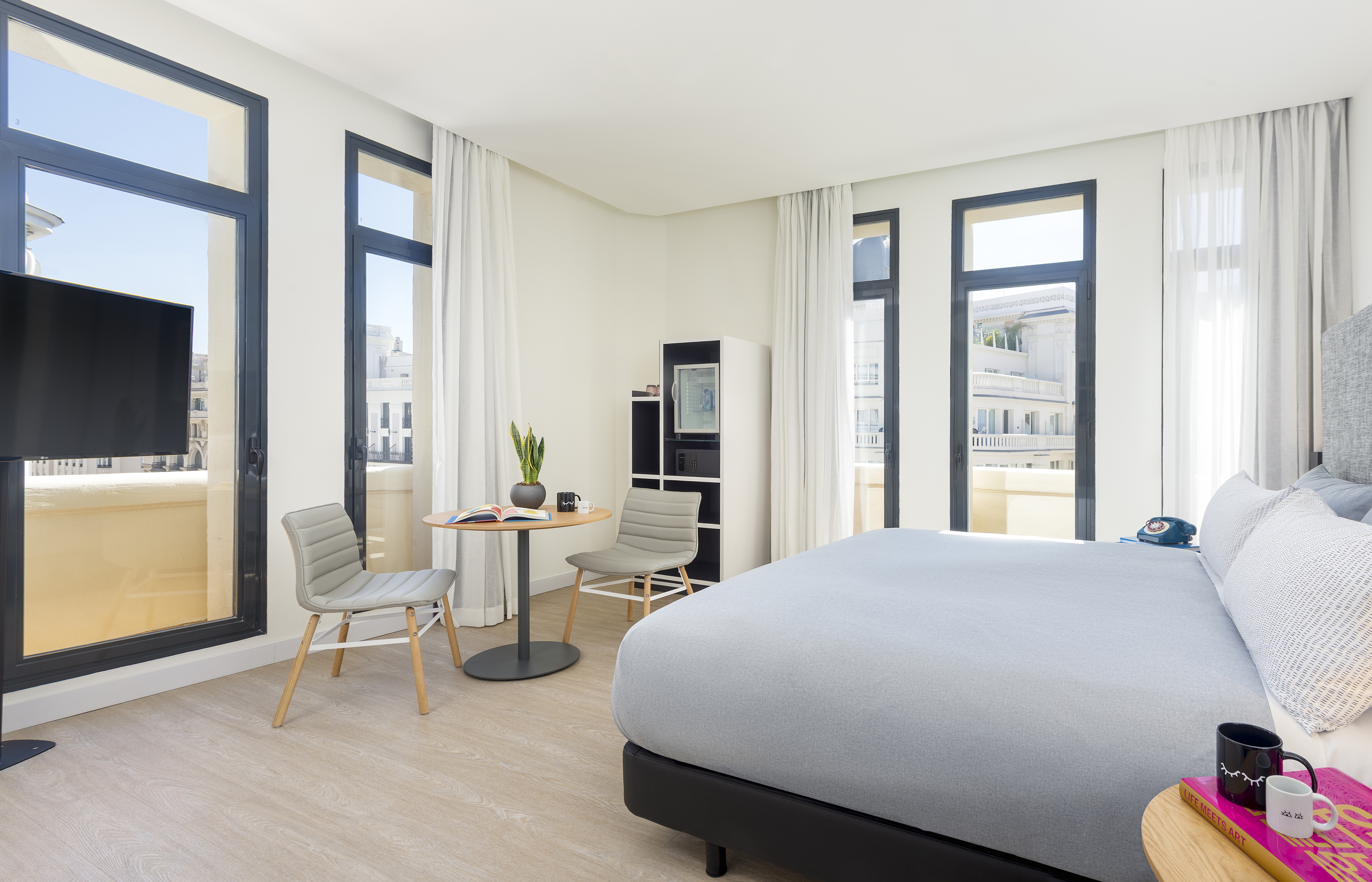 a room with a bed and chairs