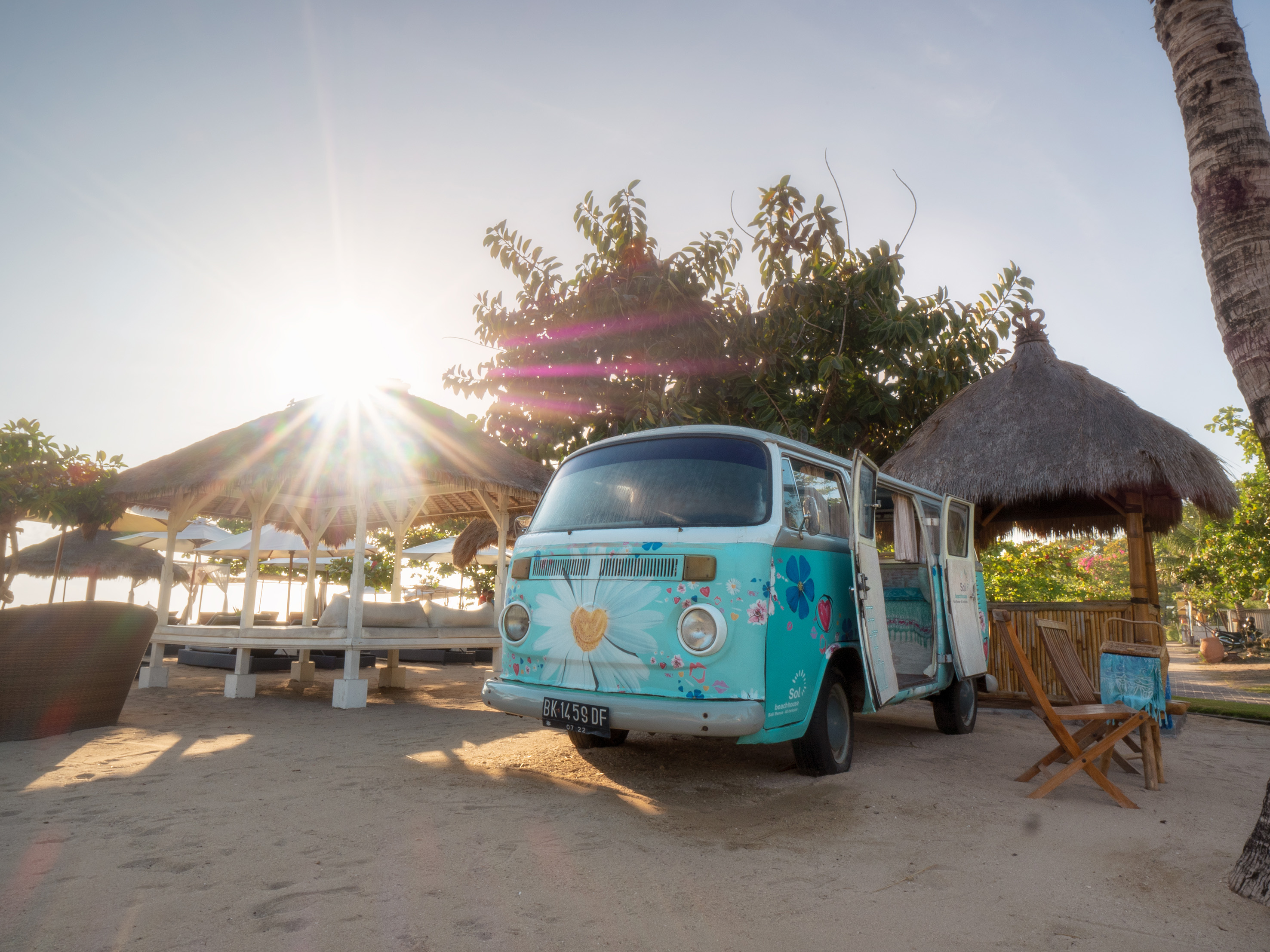 a blue van parked on a sandy beach