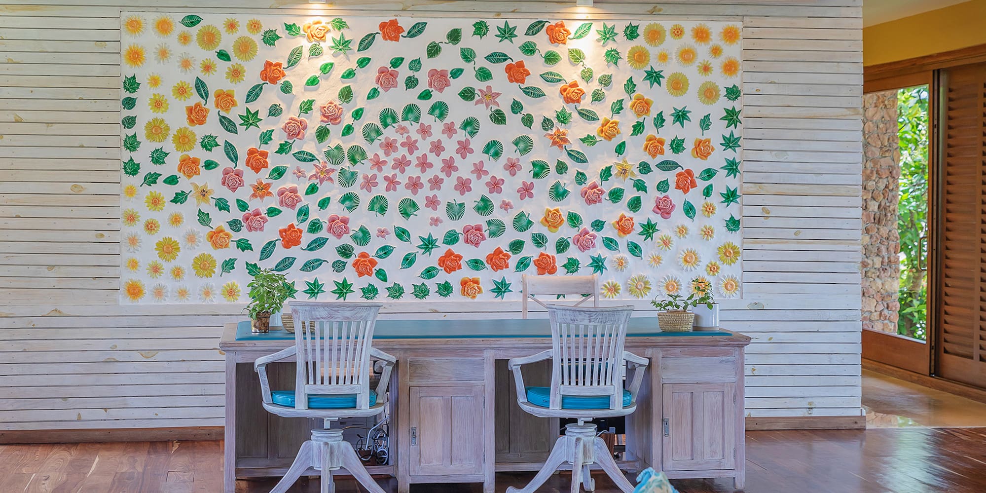 a room with a table and chairs and a wall with flowers on it