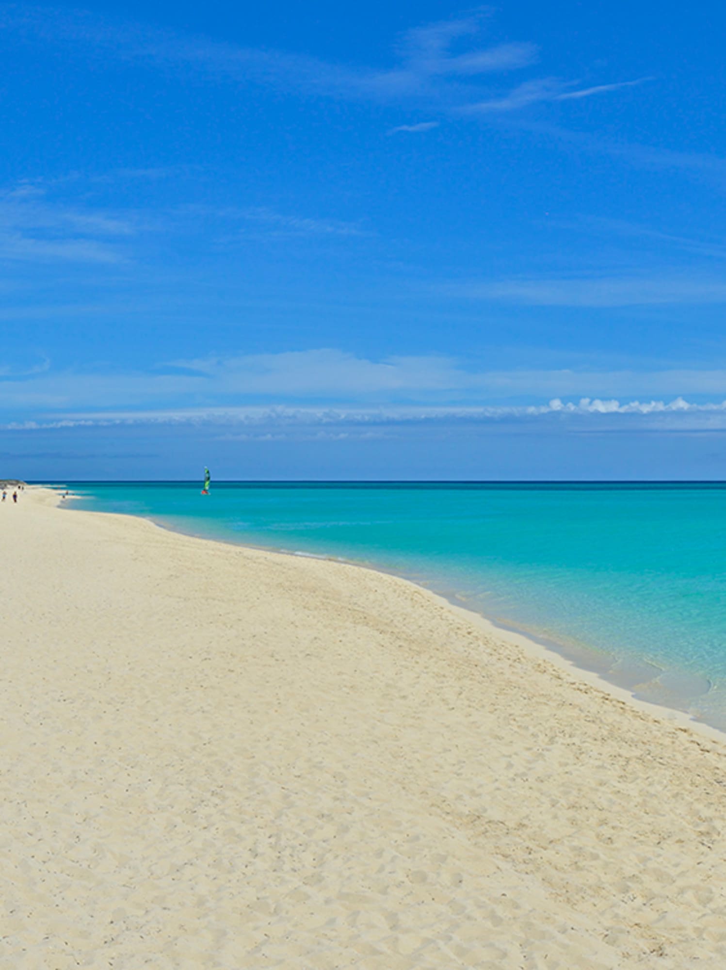a beach with blue water and blue sky