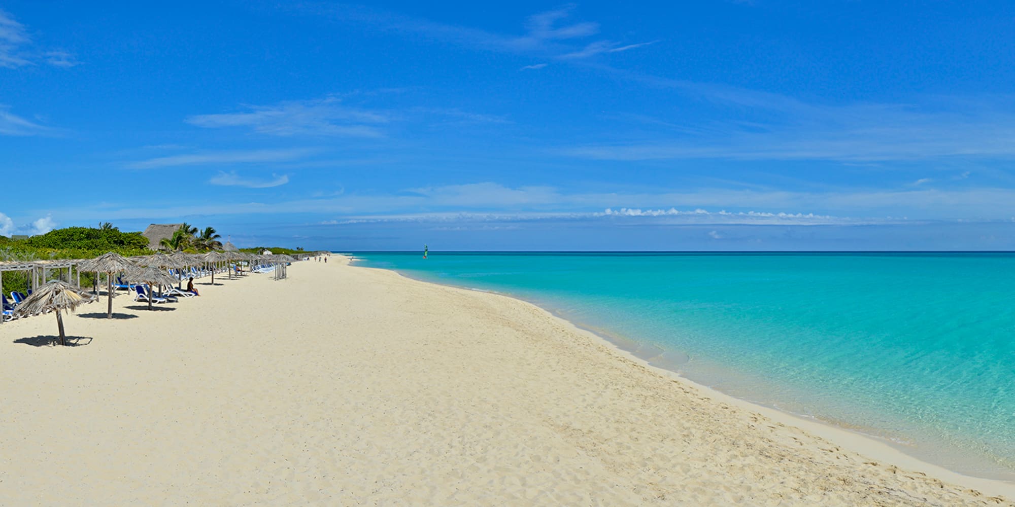 a beach with blue water and blue sky