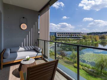 a balcony with a view of a river and a couch