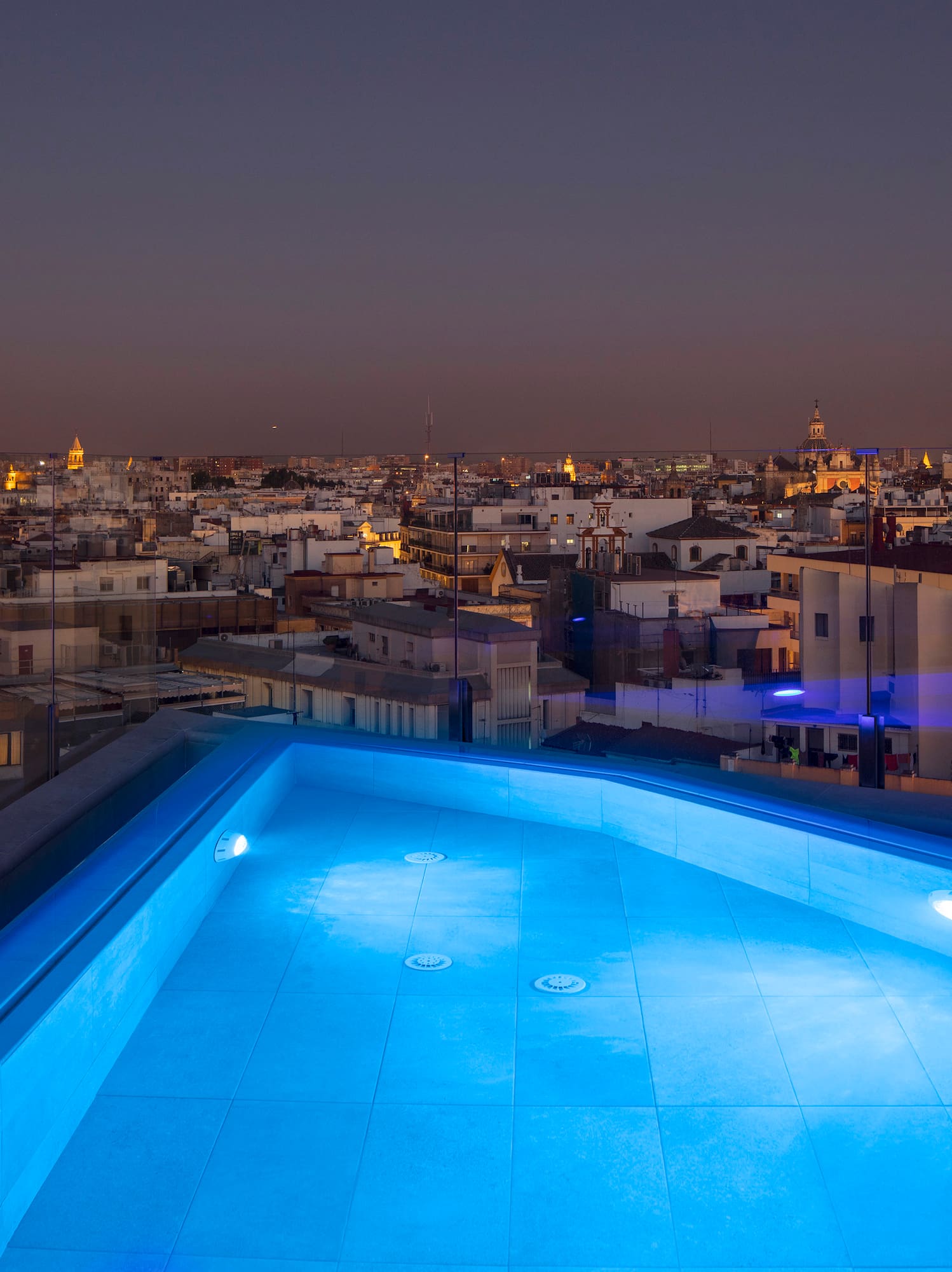 a rooftop pool with lights on