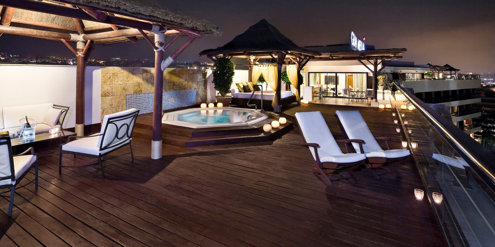 a deck with chairs and a hot tub on a rooftop