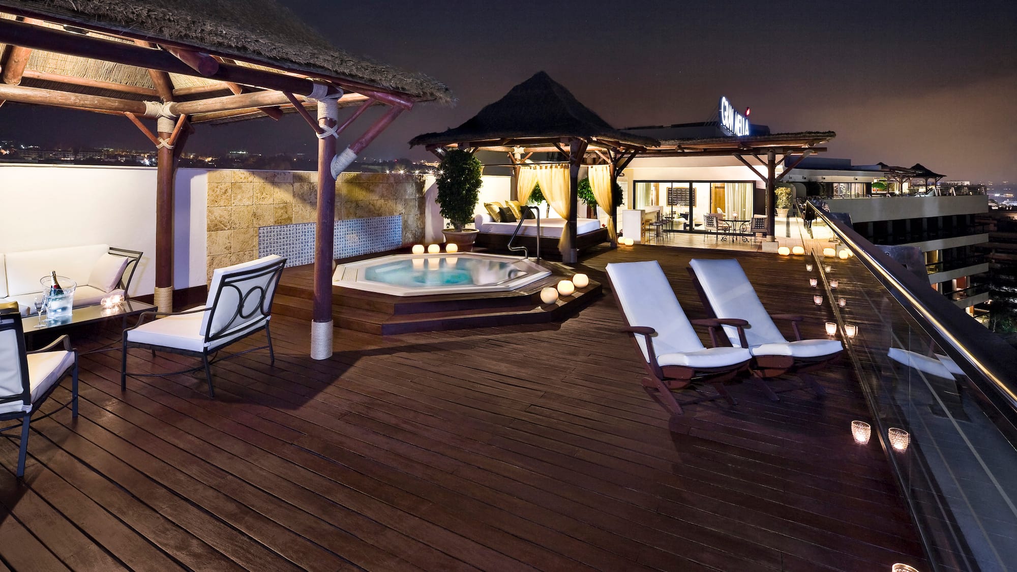 a deck with chairs and a hot tub on a rooftop