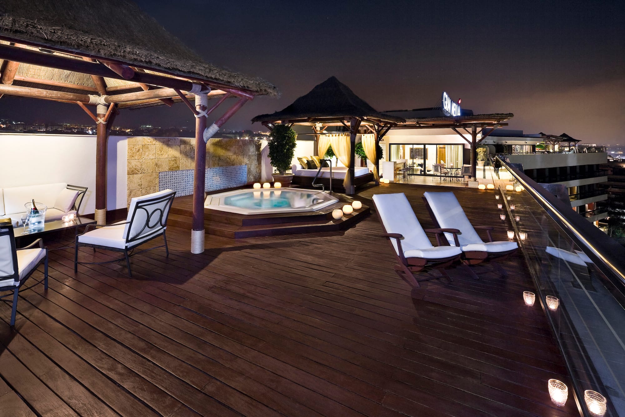 a deck with chairs and a hot tub on a rooftop