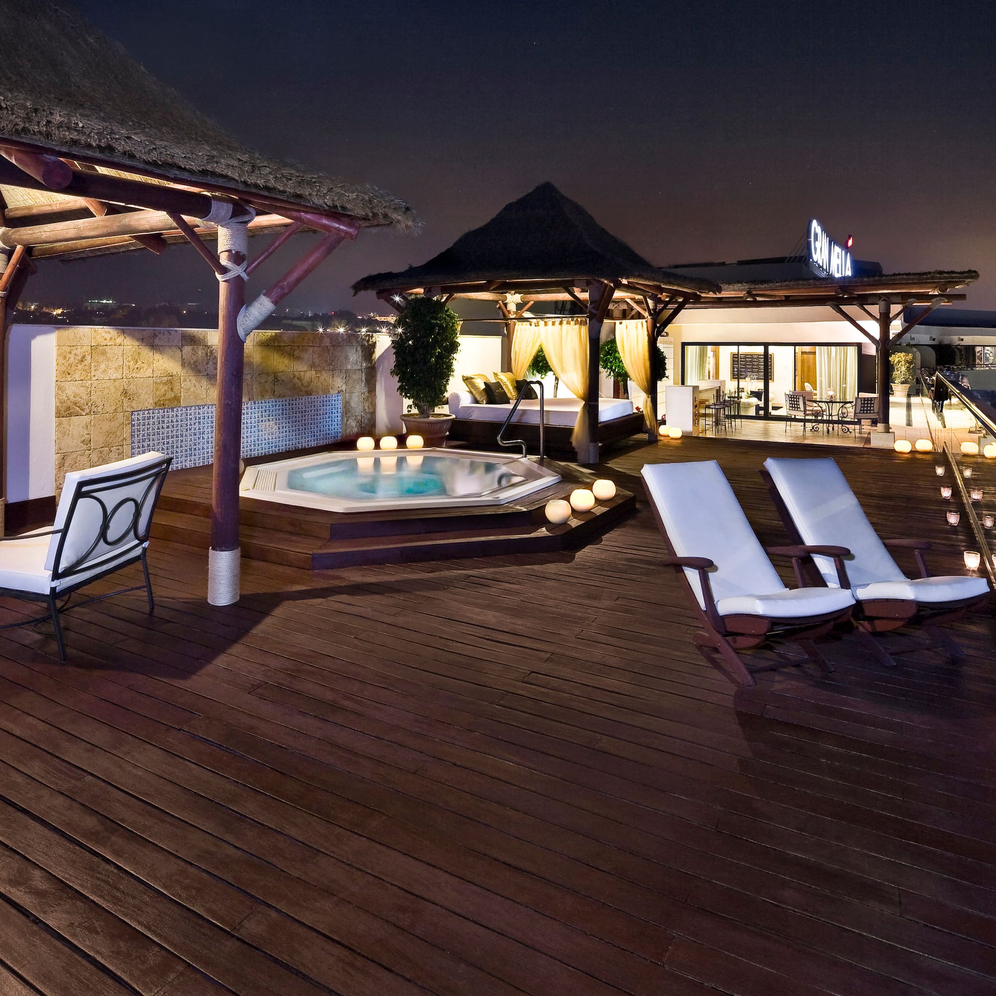 a deck with chairs and a hot tub on a rooftop