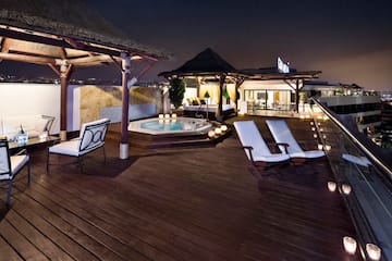 a deck with chairs and a hot tub on a rooftop