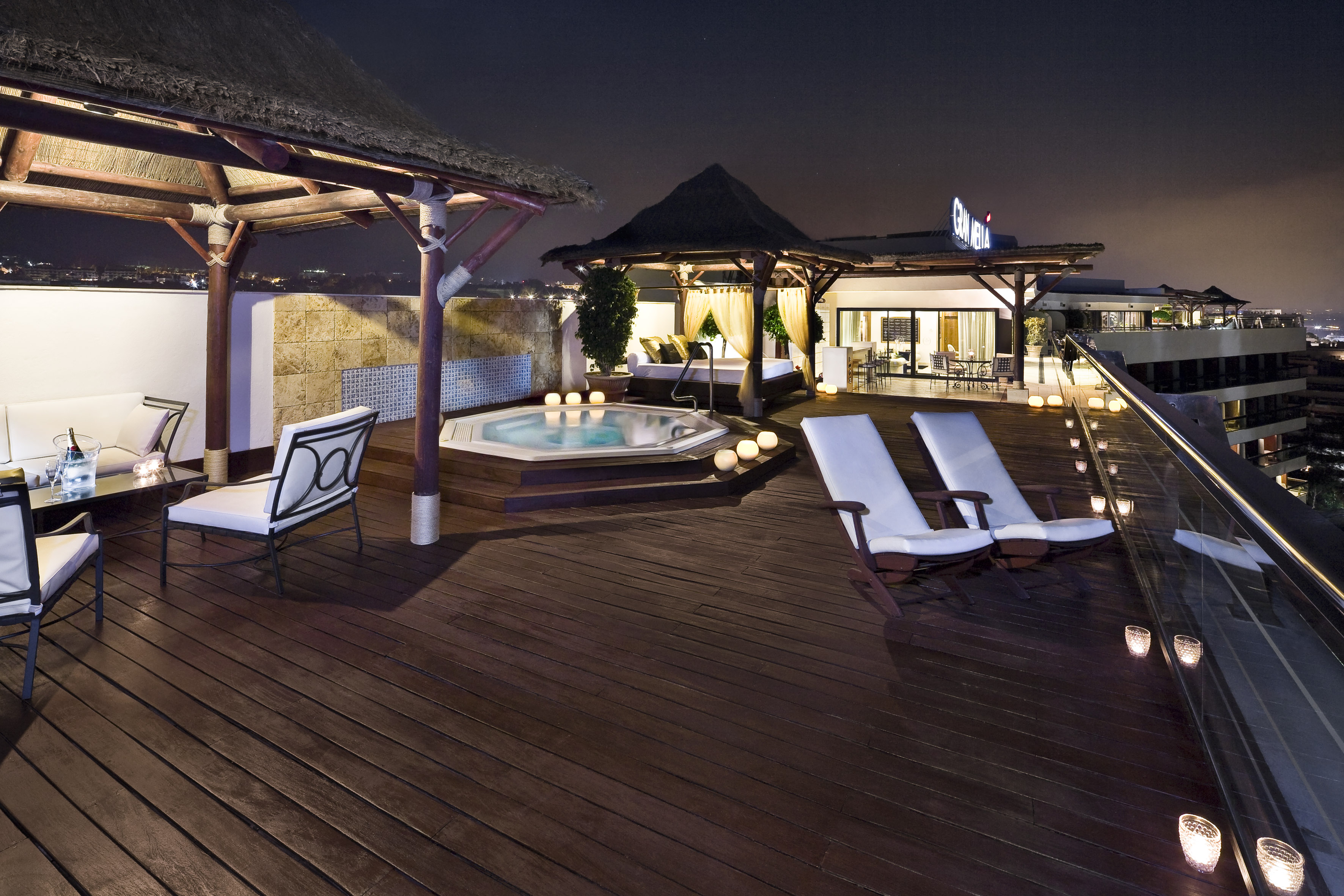 a deck with chairs and a hot tub on a rooftop