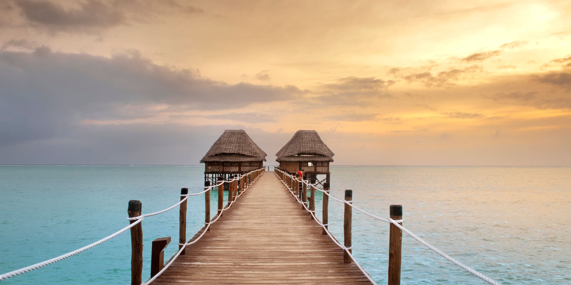 a long wooden bridge leading to a beach