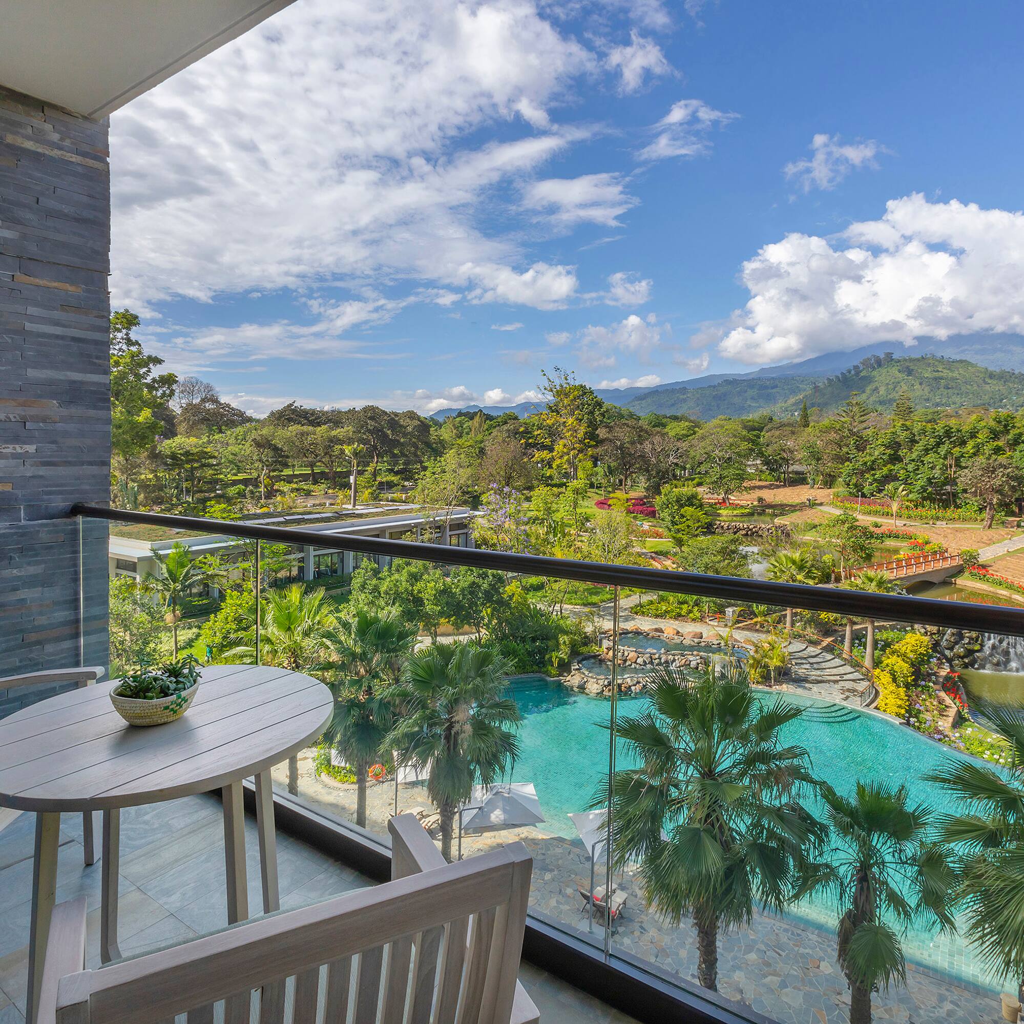 a balcony with a table and chairs and a pool
