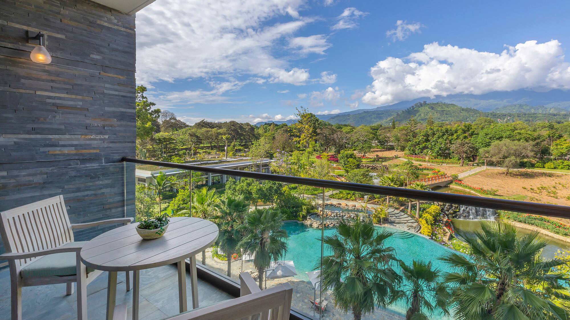 a balcony with a table and chairs and a pool