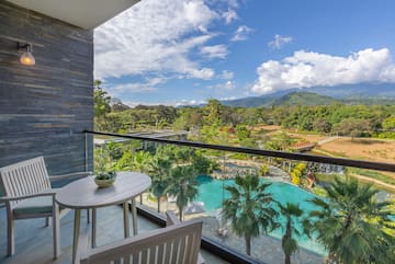 a balcony with a table and chairs and a pool