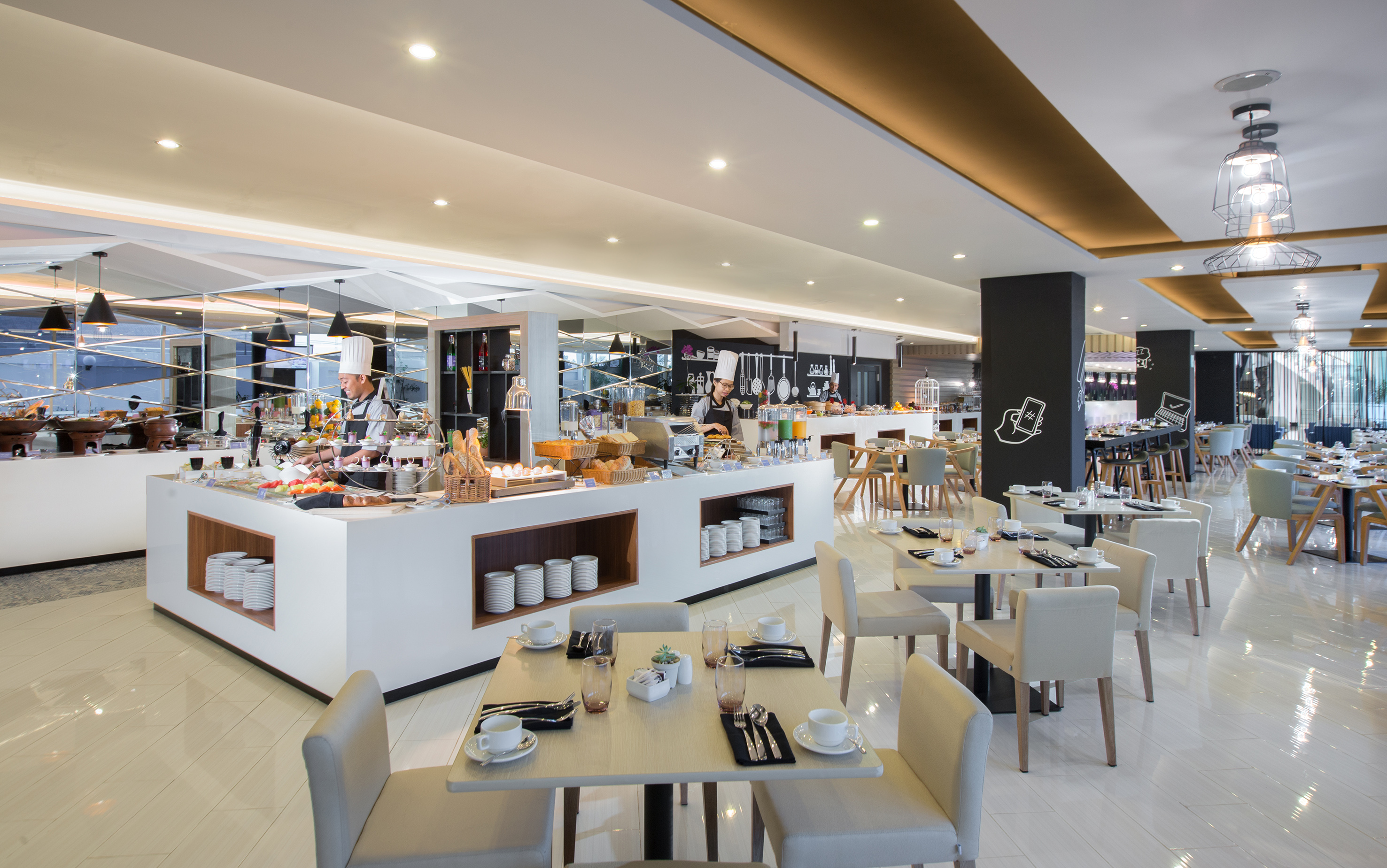 Modern hotel restaurant buffet with chef, diverse food, and set tables.