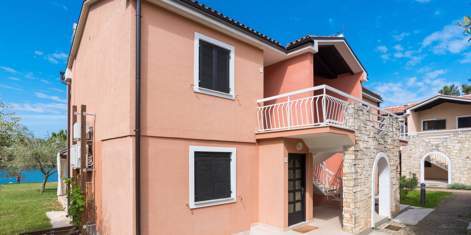a house with a stone wall and a balcony