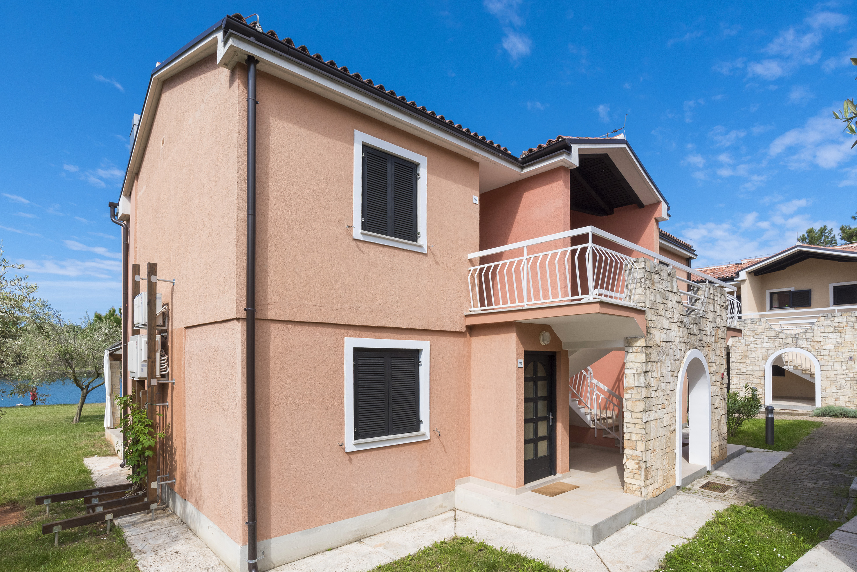 a house with a stone wall and a balcony