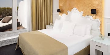 a bed with white pillows and a gold wall