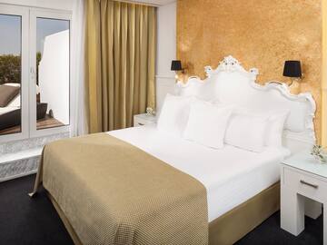 a bed with white pillows and a gold wall