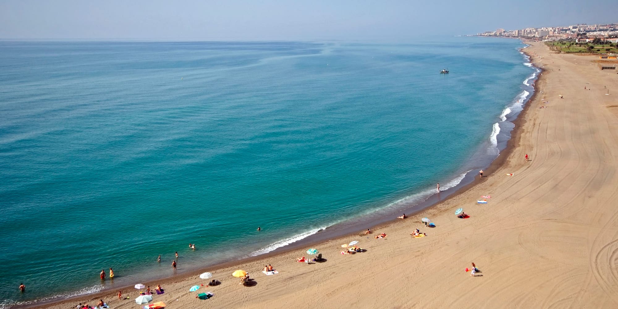 a beach with people and umbrellas