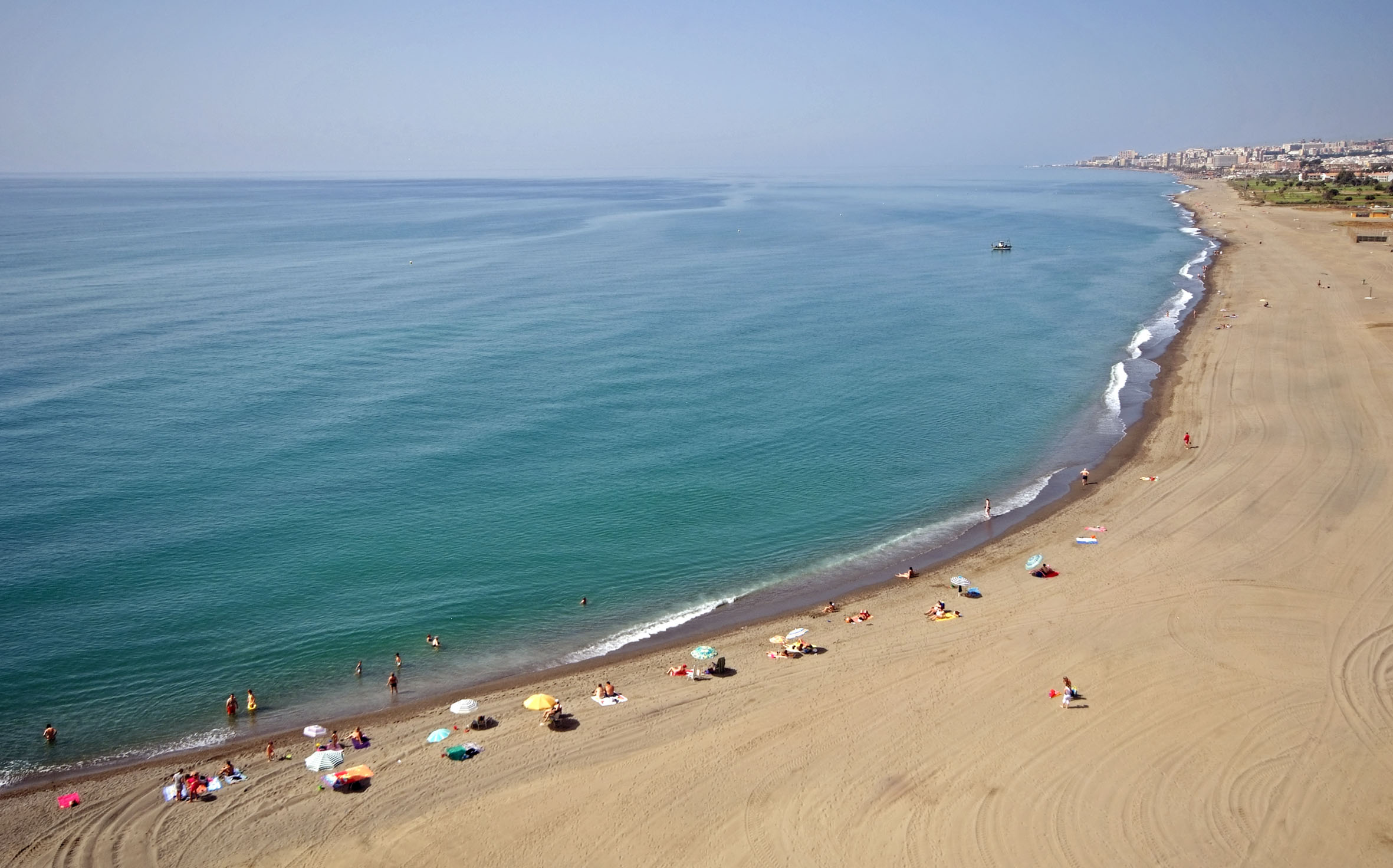 a beach with people and umbrellas