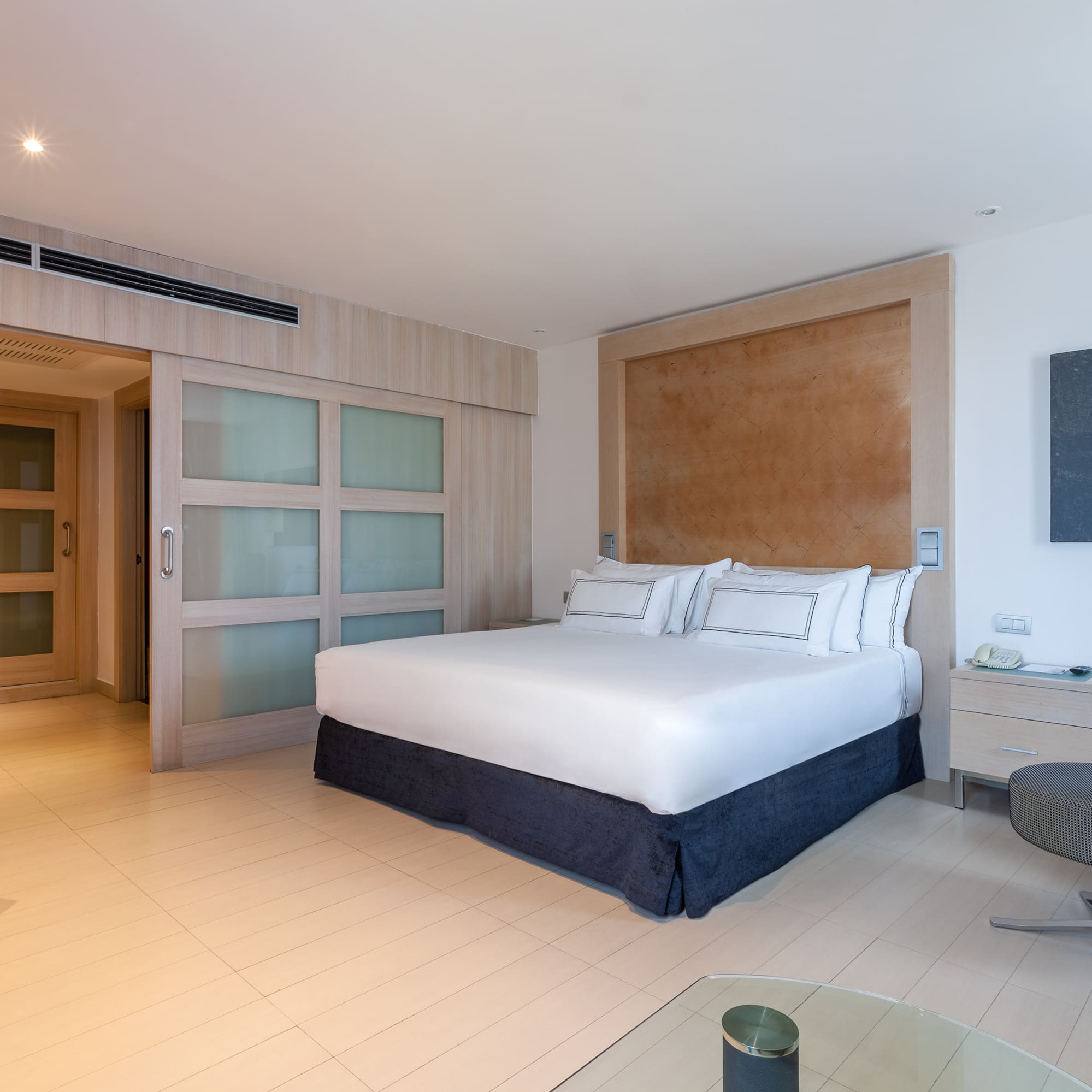 a bedroom with a bed and a glass table