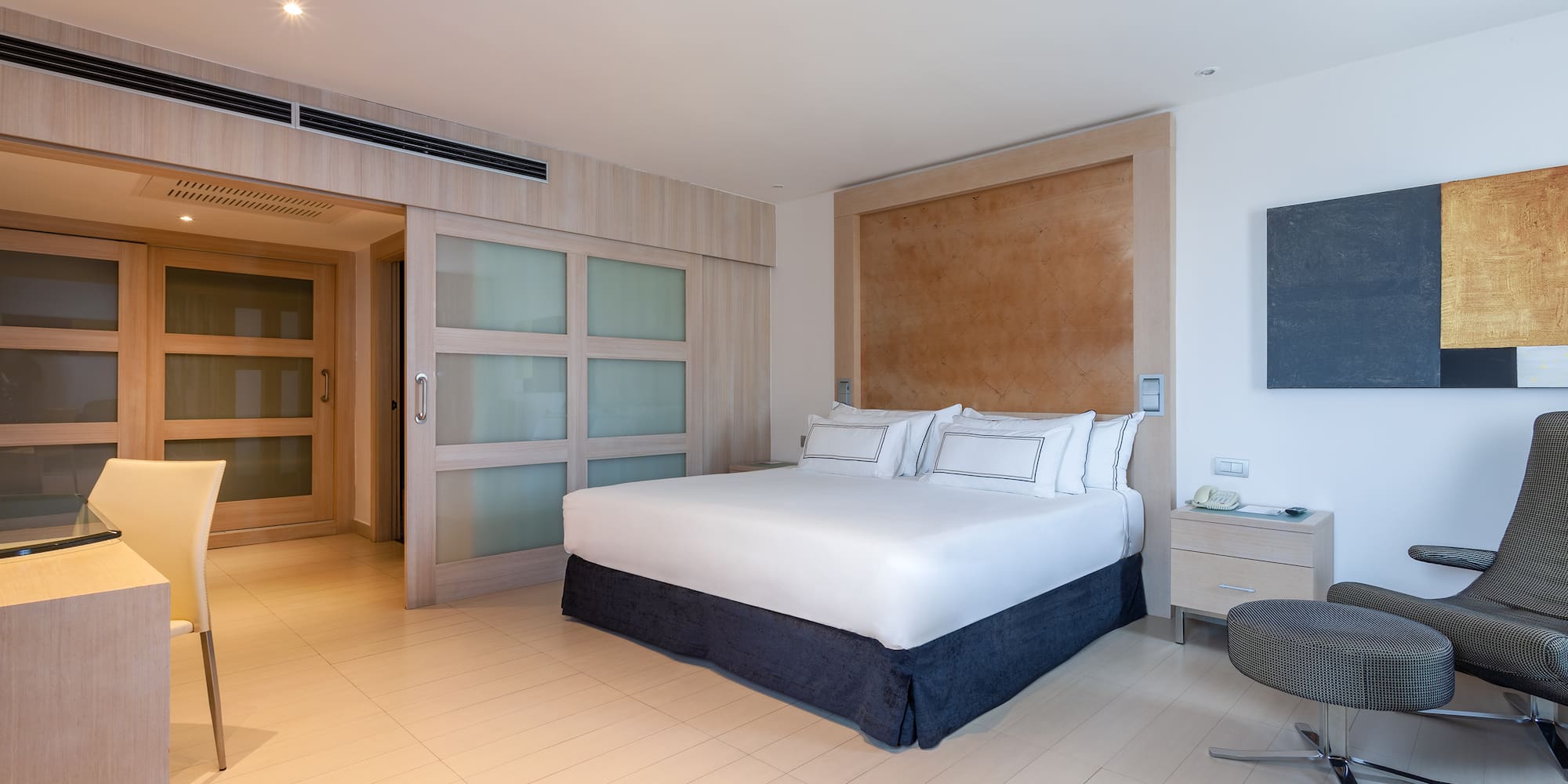 a bedroom with a bed and a glass table