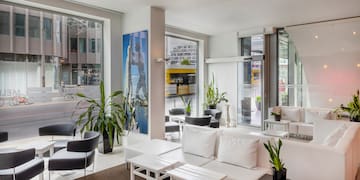 a room with white furniture and tables and plants