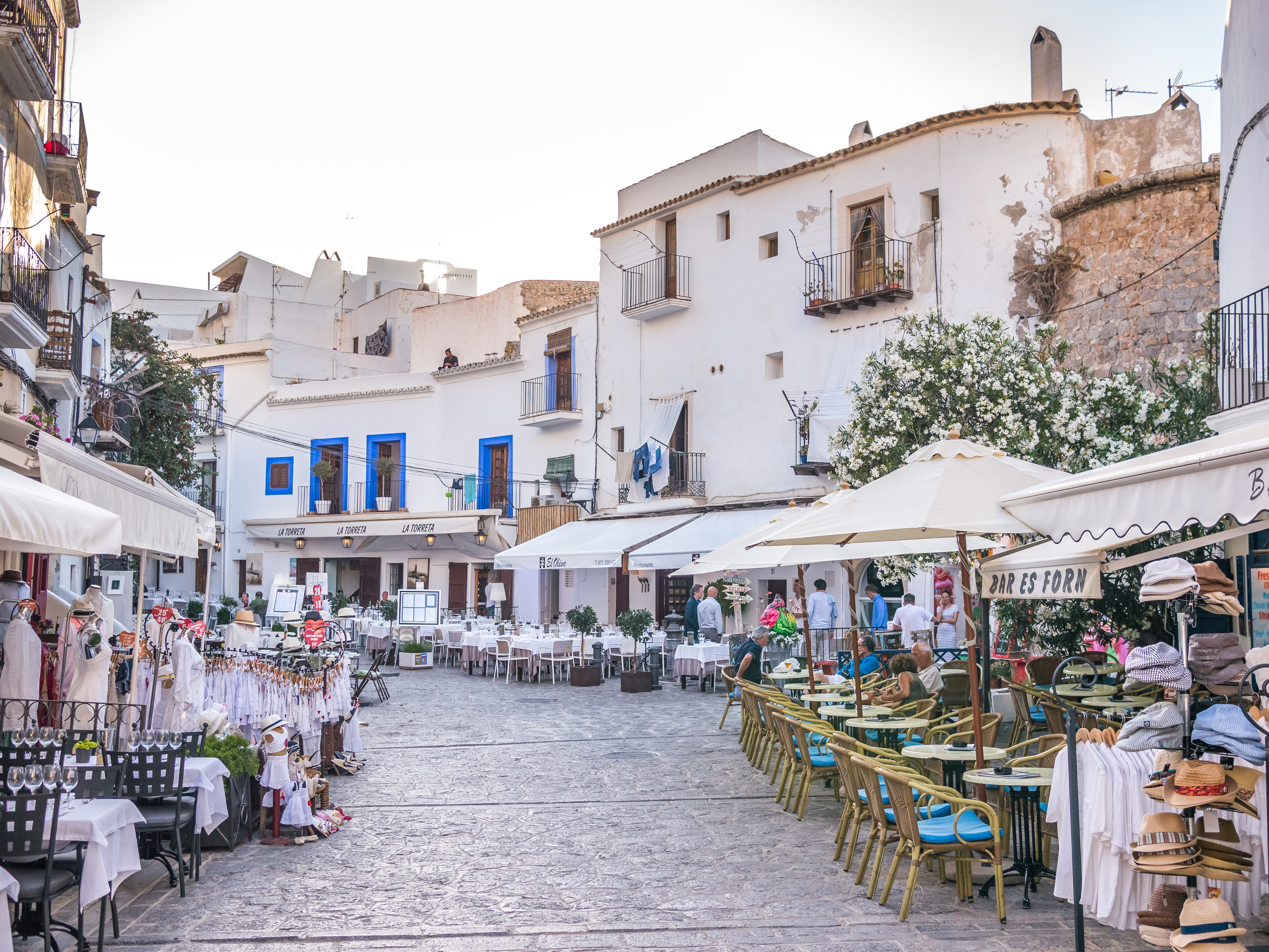 a street with tables and chairs and umbrellas
