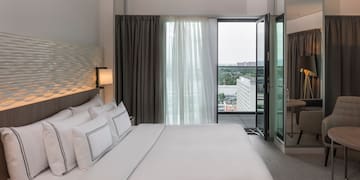 een bed met witte lakens en een lamp in een hotelkamer