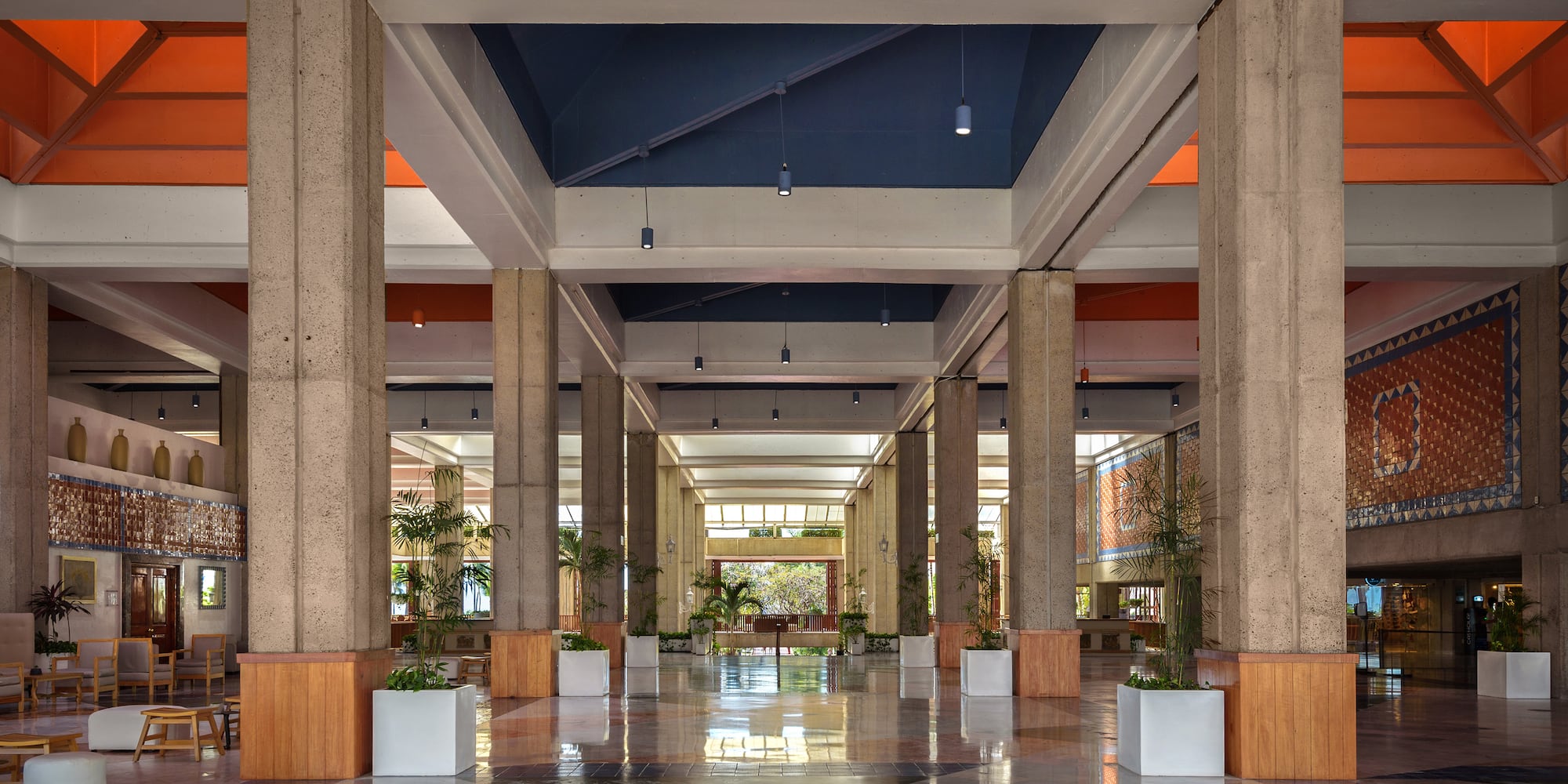 a large hall with columns and plants