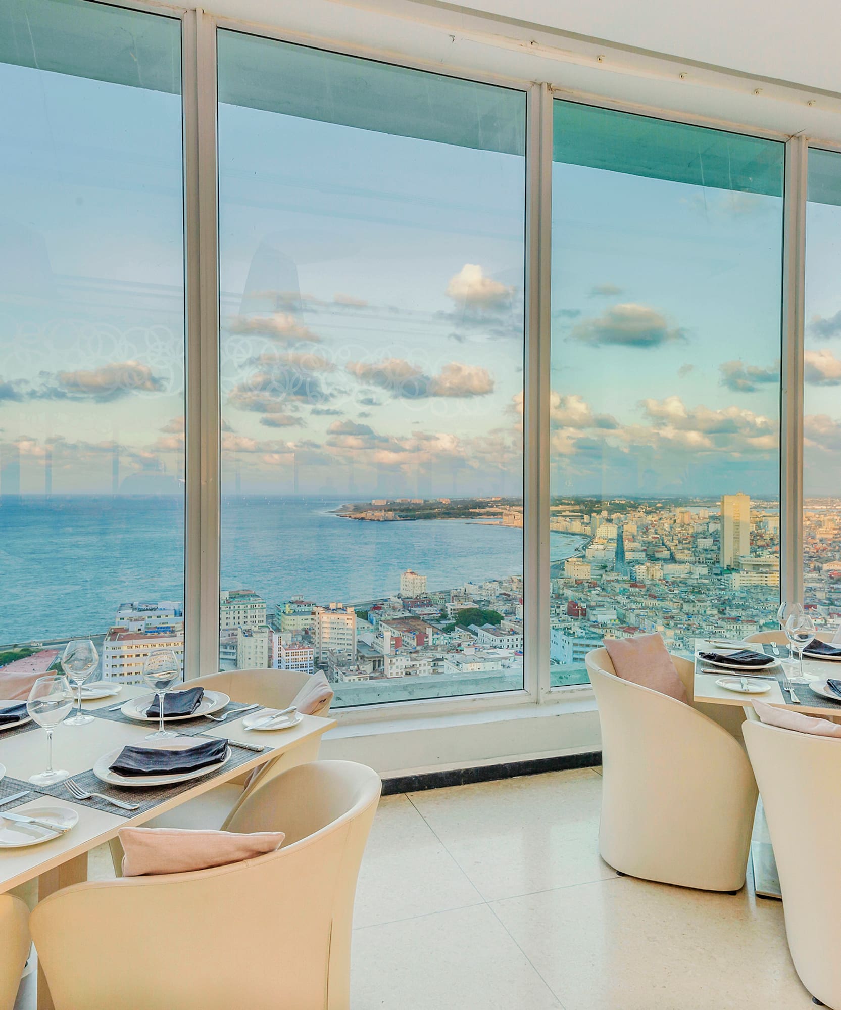 a dining room with large windows overlooking a city