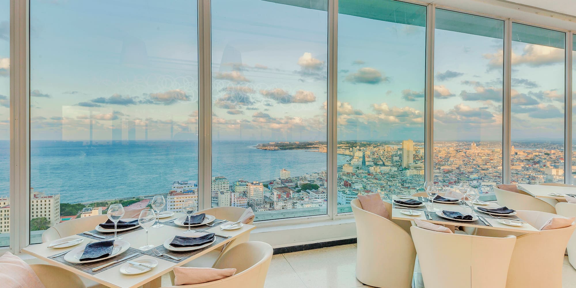 a dining room with large windows overlooking a city