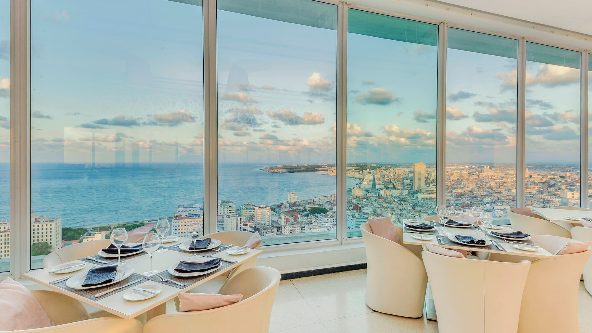 a dining room with large windows overlooking a city