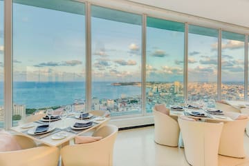 a dining room with large windows overlooking a city